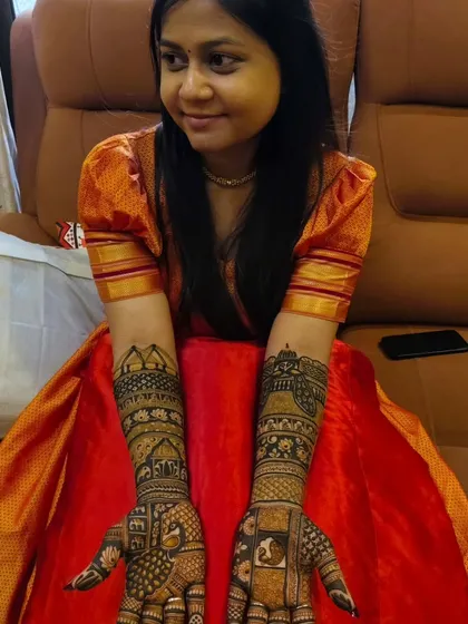 A smiling bride proudly displaying her detailed bridal mehandi. Her happiness is my biggest achievement.
