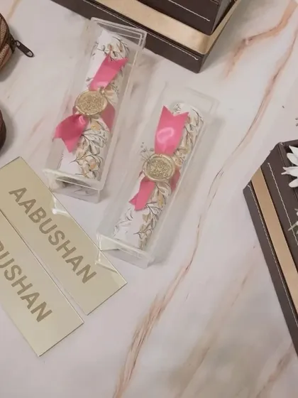 Elegance in a scroll. For the 'Aabushan' event, we created these unique scroll invitations, sealed with a wax stamp and presented in a clear box for a touch of classic luxury.