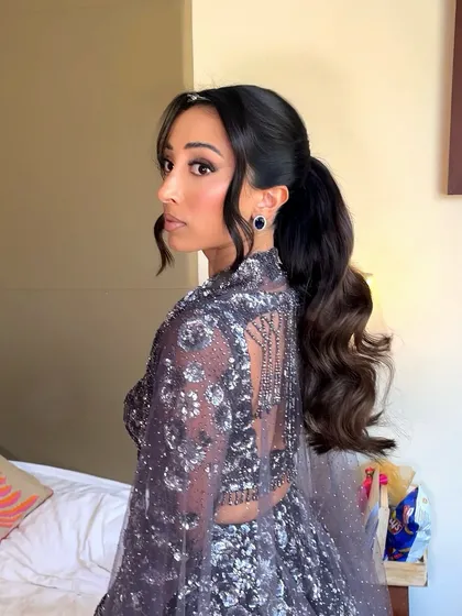 A side profile of the wavy ponytail. This is a very flattering style that elongates the neck and shows off the client's earrings.