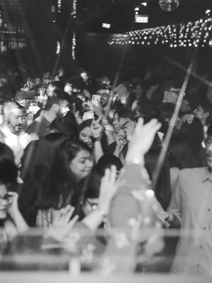 A black and white shot of the dance floor, capturing a timeless moment of collective celebration. The energy is just as powerful without color.