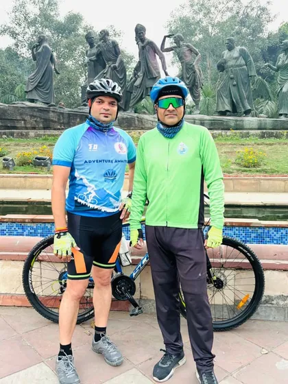 Two members at the Gyarah Murti. The sculpture represents the Dandi March, a journey of determination, much like our rides.