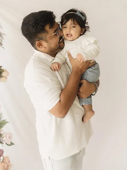 A father holds his daughter close, both sharing a happy smile. This image beautifully captures the special bond between a dad and his little girl.