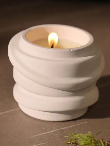 A close-up of our sculptural white candle with a swirl texture. Its clean lines and artistic form make it a beautiful decorative object, even when unlit.