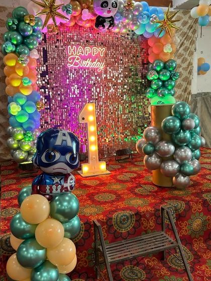 A wider view of a superhero-themed birthday, showing a Captain America foil balloon and a mix of character elements.