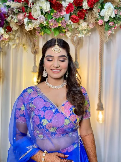Simran looking radiant and happy. The makeup features a pop of color on the eyes to match her beautiful blue and pink lehenga.