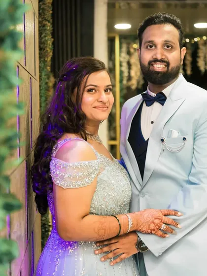 A classic posed portrait of the couple, showcasing their coordinated blue and silver engagement outfits.