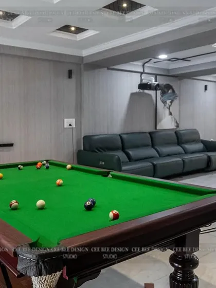 A spacious entertainment room featuring a pool table, a large leather sofa, and modern art.