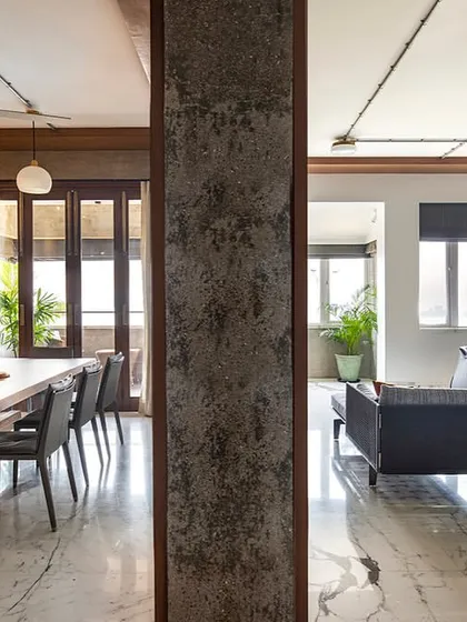 This image captures the essence of our open-plan design philosophy. The living and dining areas of 'The Canvas' apartment flow into one another, separated only by a raw concrete column, creating a unified space that is perfect for both family life and entertaining.
