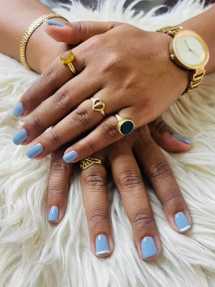 A chic and trendy look with a dusty blue gel polish on short, natural nails, featuring a minimal white tip on the index finger.