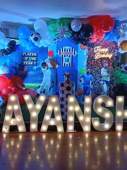 A sports fan's ultimate birthday bash! This setup is packed with energy, featuring a dynamic backdrop with various sports elements, balloon columns, and life-sized cutouts of favorite players. The giant light-up name and age make the birthday boy feel like the player of the year.