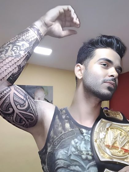 A client showing off his completed Polynesian full-sleeve tattoo. This style is perfect for creating a strong and masculine look that covers the entire arm.