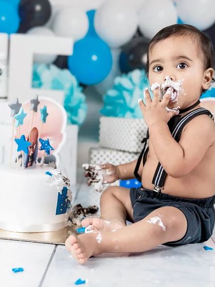 This little one is getting a full taste of his first birthday cake! A close-up shot capturing the messy details of a fun cake smash.