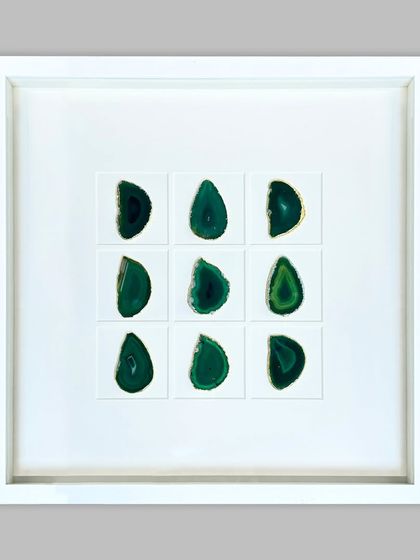 This striking piece features nine polished green agate stones arranged in a grid. The stones are floated on a clean white background within a deep shadow box, creating a modern, minimalist piece of natural art.