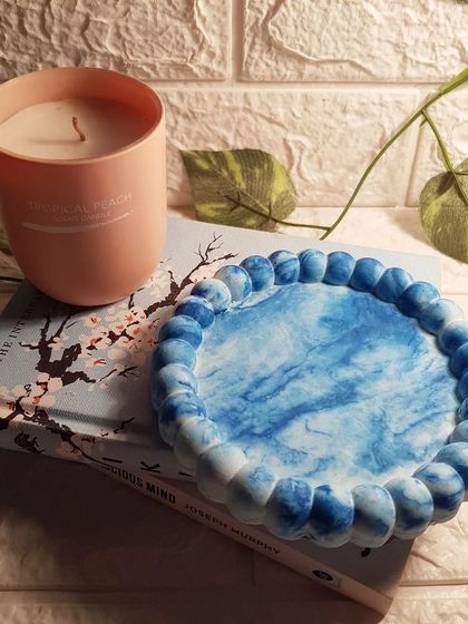 This bubble tray is made from concrete with a blue and white marble effect that looks like ocean waves. It’s a calming piece for a coastal or beach-themed room.