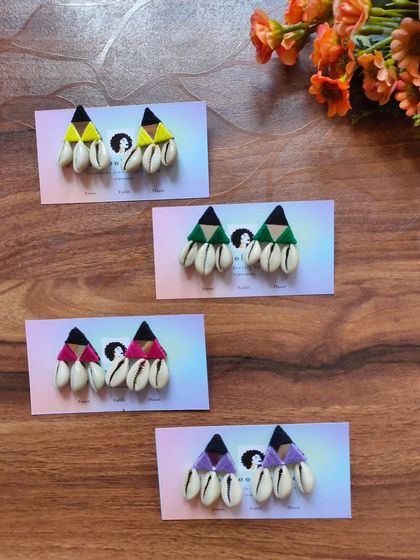 These fun and bohemian shell earrings, also known as kodi earrings, are perfect for a beachy or festive look. They are available in yellow, green, pink, and purple.