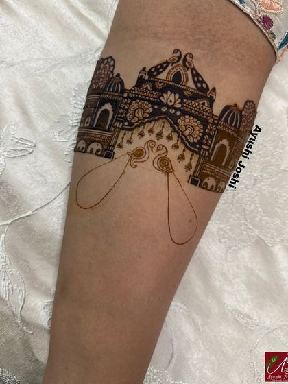The first stage of a royal bridal mehendi, with the outline of a palace gate and peacocks. A strong foundation is key to a symmetrical and grand design.