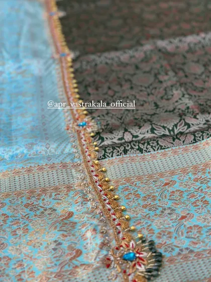 A close-up of the intricate border, showing the detail of the stone and beadwork.