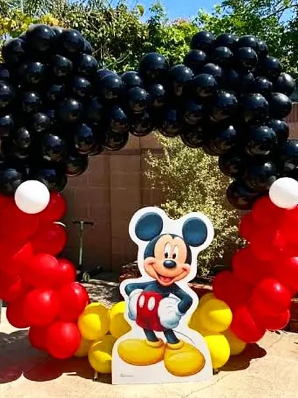 An outdoor Mickey Mouse themed balloon arch. This is a great way to welcome guests to a birthday party and set a fun tone right from the entrance.
