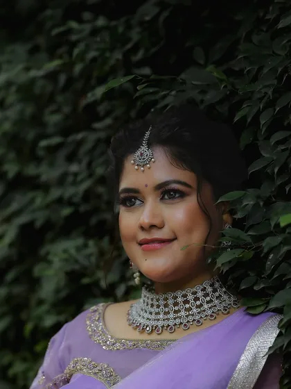A close-up portrait that provides a clear view of the intricate web-like design of the American diamond choker and matching maang tikka.