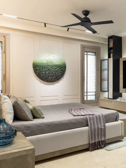 This wide shot of the master bedroom shows the circular ombre art piece and the minimalist TV unit. The design choices create a serene and inviting atmosphere, reflecting our client's preference.