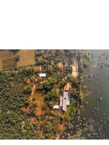 Another aerial perspective, capturing the relationship between the built form, the cultivated landscape, and the wildness of the lake's edge.