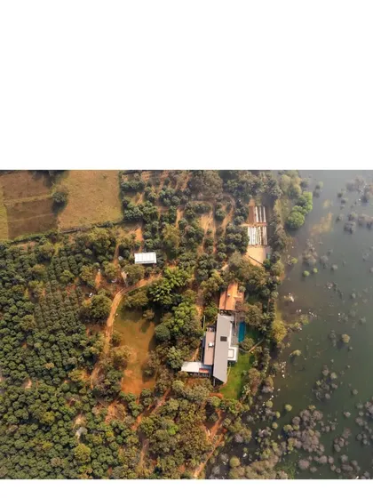 Another aerial perspective, capturing the relationship between the built form, the cultivated landscape, and the wildness of the lake's edge.