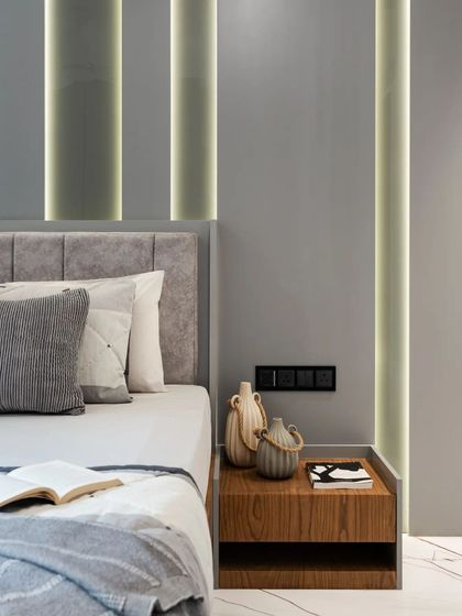 In the son's bedroom, I used integrated vertical light strips to create a modern and dynamic feature on the grey accent wall. The clean lines and minimalist bedside table maintain a sleek, contemporary look that is both stylish and calming.