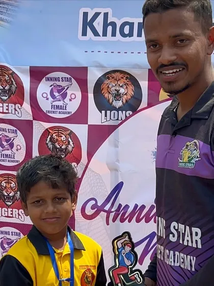 Another happy player receiving his award from the coach, celebrating his performance during the anniversary match.