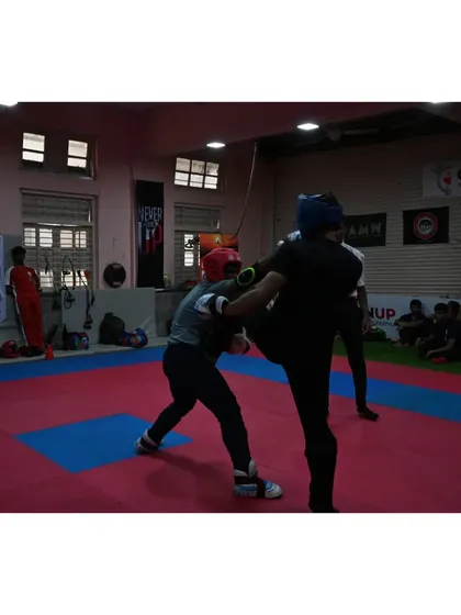 An action shot from the 4th Mumbai City Kickboxing Championship. Our fighters are trained to maintain composure and strategy under pressure, seen here as they exchange blows in a competitive bout.