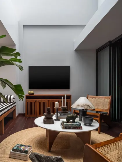 This sky-lit lounge features a mix of seating I designed, including a striped bench and caned armchairs. The arrangement creates a versatile space for watching TV, reading, or conversing.