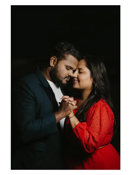A dramatic close-up against a black background, focusing entirely on the couple's intimate connection and emotion.