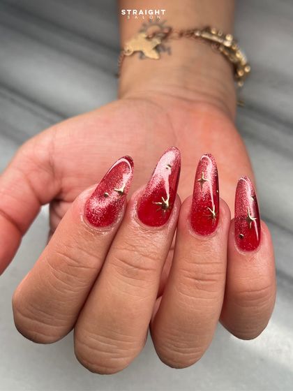 This shot captures the magnetic shimmer of the red cat-eye polish. The light creates a bright streak across the nail, giving it incredible depth and movement.