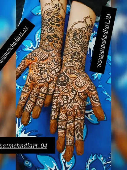 Another view of this intricate floral mehendi design. The solid-filled fingertips are a classic touch that provides a beautiful contrast to the detailed work on the hands and arms.
