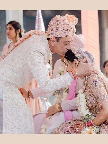 A father's emotional kiss for his daughter on her wedding day. A powerful, candid moment that speaks volumes about family bonds and the significance of the day.