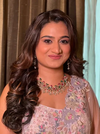 A close-up portrait of Vini, her makeup perfectly complementing the soft colors of her outfit.