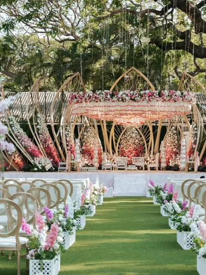 The wedding aisle view of the Lotus Mandap, set in a lush green lawn. The design is perfectly integrated with the natural surroundings, creating a harmonious and beautiful setting.