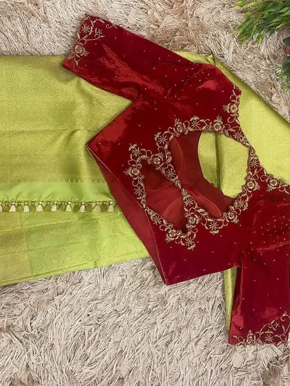 The back view of the red velvet blouse, featuring a beautiful cutwork design framed with intricate gold embroidery.