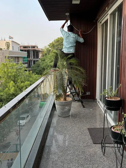 No location is too difficult. Here, my team is installing an outdoor camera on a residential balcony in GK-1, ensuring the perimeter of the property is just as secure as the inside.