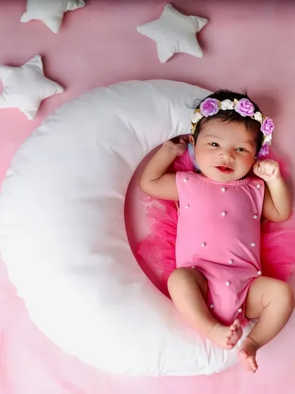 An adorable, wide-eyed look from the baby in the celestial moon and stars setup. It's a wonderful example of capturing a baby's alert and curious moments.