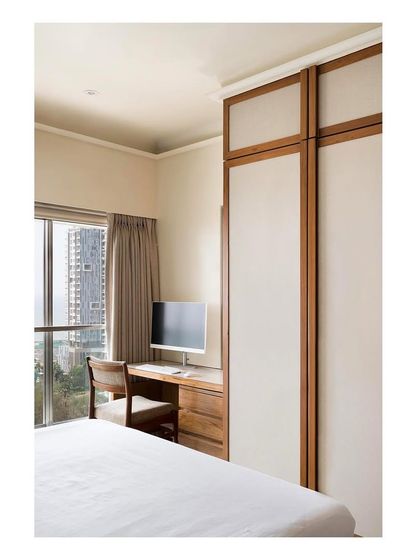 This bedroom combines rest and work with a compact study nook built next to the window. The design prioritizes natural light and efficient use of space.