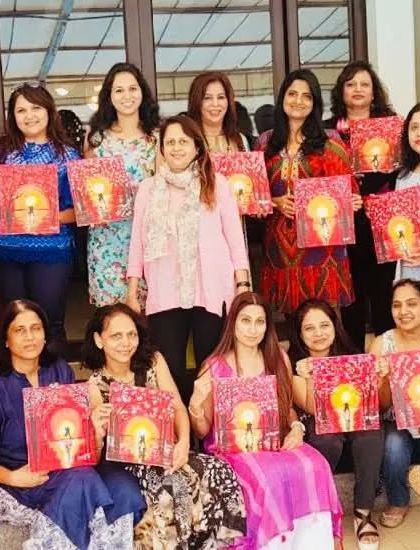A large group of women proudly showing the Buddha paintings they created. Each canvas is a reflection of their inner peace and focus during the session. These workshops are perfect for large gatherings, ensuring everyone participates and has a great time.