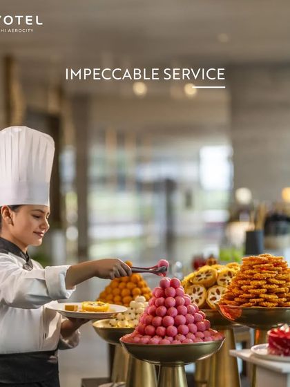 A chef at Novotel prepares a platter of colourful Indian sweets. This image showcases the impeccable service and delightful dessert buffets available at my hotel restaurants.