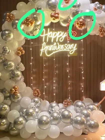 Here is another option for a first anniversary, using a silver, white, and rose gold color scheme. The circular balloon arch is decorated with fairy lights and a neon sign, creating a beautiful backdrop for your celebration.