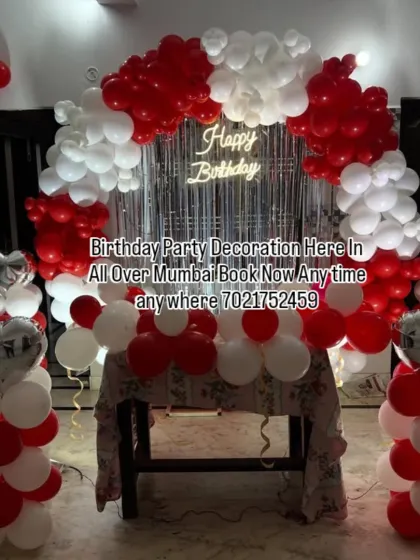 A classic red and white balloon arch decoration for a home party. This setup includes a shimmer curtain, a neon sign, and matching balloon pillars, perfect for birthdays or anniversaries.