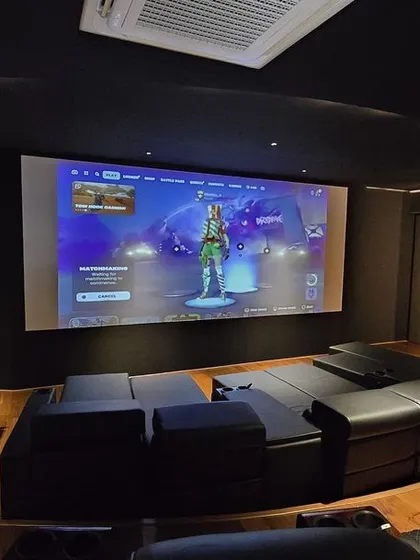 Your home theater can be a space for more than just movies. This ultra-modern setup in Nellore is perfect for immersive gaming, featuring sleek black interiors, curved custom loungers, and a high-performance 4K projector for a lag-free, larger-than-life experience.