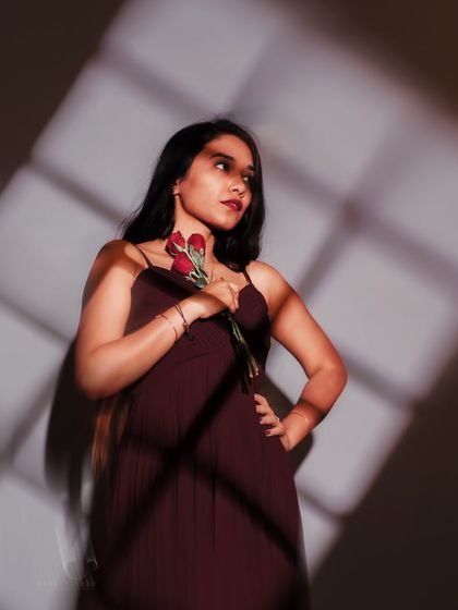 Looking away, caught in a pattern of light. This cinematic portrait tells a story of longing or contemplation, with the shadows creating a beautiful, graphic element.