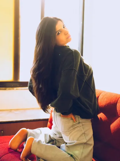 A relaxed and natural pose, using the bright window light to create a fresh and airy feel.