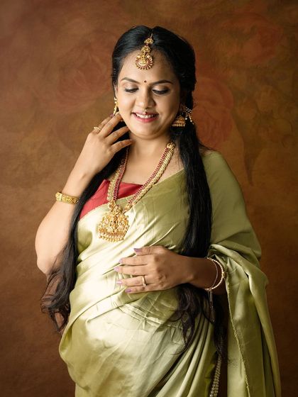 A beautiful close-up showing the intricate details of the traditional jewelry and the serene expression of the mom-to-be.