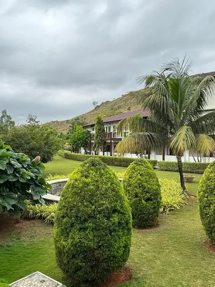 The manicured gardens and topiary add a sense of order and peace to the wilder natural landscape. It's a balance of curated beauty and raw nature.