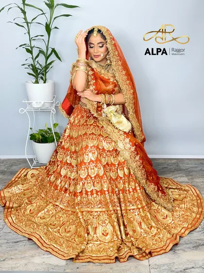 A full view of the bride seated, her lehenga spread out in all its glory.